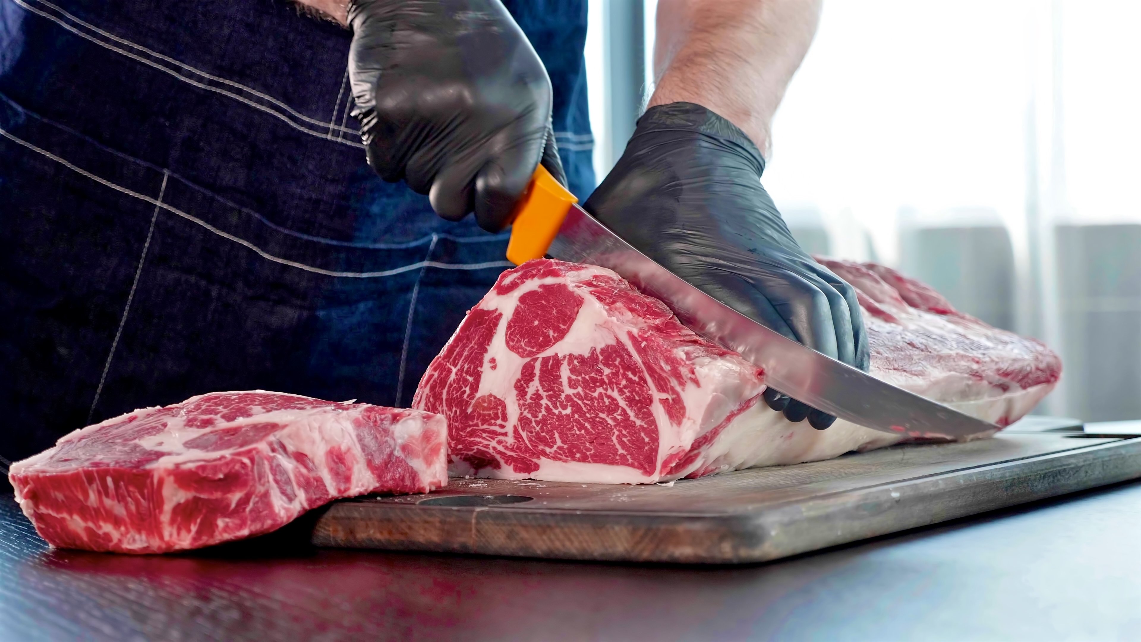 chef-cuts-raw-meat-on-the-wood-board-with-the-knif-2023-11-27-05-37-01-utc.jpg