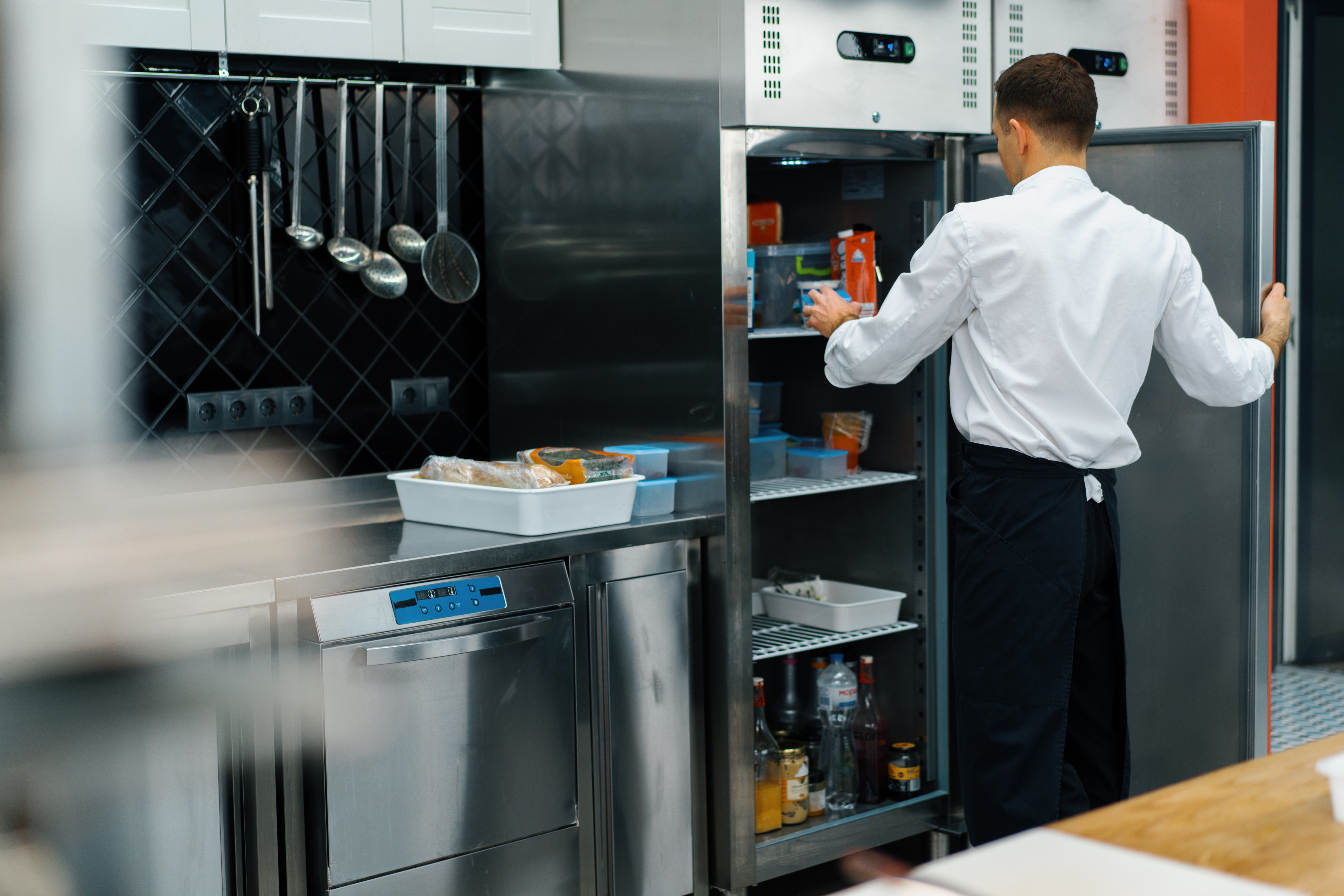 professional-kitchen-chef-looks-into-the-fridge-an-2023-12-21-18-19-07-utc.jpg